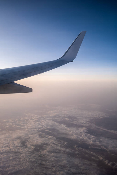 Lentäminen ja matkustaminen, näkymä lentokoneen ikkunasta siiven auringonlaskun aikaan
. - Valokuva, kuva