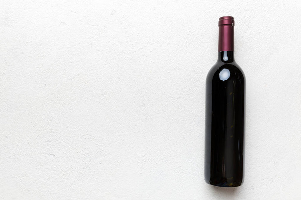 One Bottle of red wine on colored table. Flat lay, top view wth copy space. - Foto, imagen