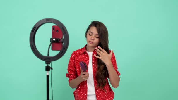 Mutlu genç kız güzellik blogcusu saç fırçası kullanıyor ve güçlü sağlıklı saçlarının ve saç bakımının reklamını yapıyor. - Video, Çekim