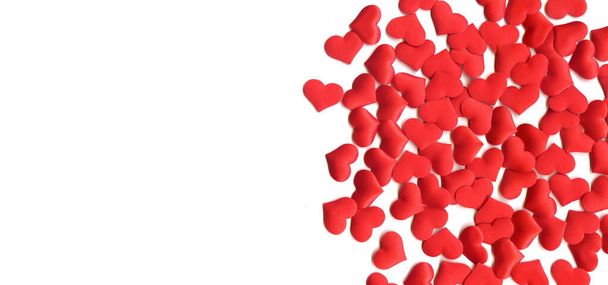 Valentine's Day background. Abstract background. a scattering of red silk hearts on a white background, a festive banner for cards, wrappers, covers. High quality photo - Foto, Imagem