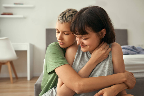 Young lesbian couple resting and hugging at home - Fotó, kép