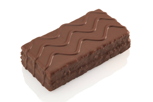 Snack enrobé de chocolat avec décor de chocolat vague. Isolé sur fond de whiye. Sentier de coupe - Photo, image