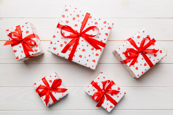 Valentinstag Zusammensetzung Hintergrund: rote Geschenkbox mit Schleife und Herz. Weihnachtsgeschenk. Blick von oben. Grußkarte zum Feiertag. - Foto, Bild
