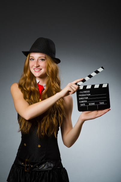 Woman with movie clapboard against grey background - Photo, Image