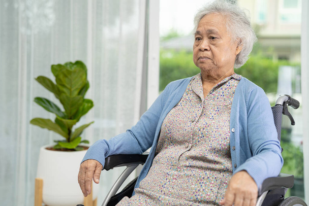 Elderly senior woman sitting on wheelchair at home, healthy strong medical concept. - Photo, Image