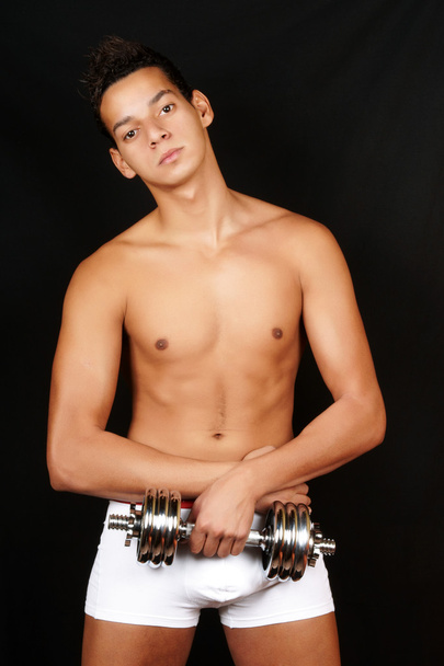 Young man with dumbbell - Foto, afbeelding
