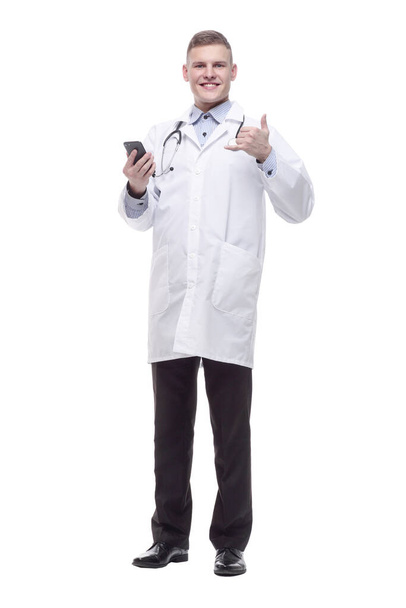 in full growth. young doctor with a smartphone. - Zdjęcie, obraz