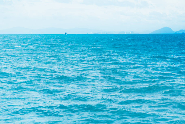 Heldere blauwe oceaan met gladde golf achtergrond. - Foto, afbeelding