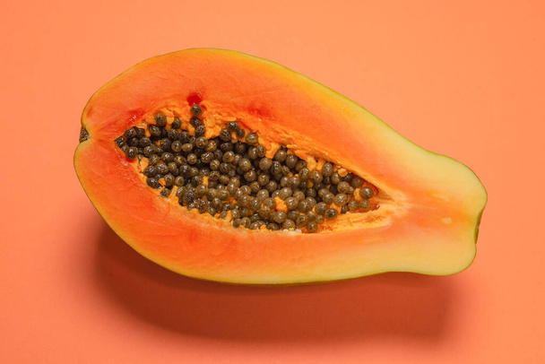 Papaya-Frucht auf orangefarbenem Hintergrund. Tropische Früchte. Halbe Papaya.  - Foto, Bild