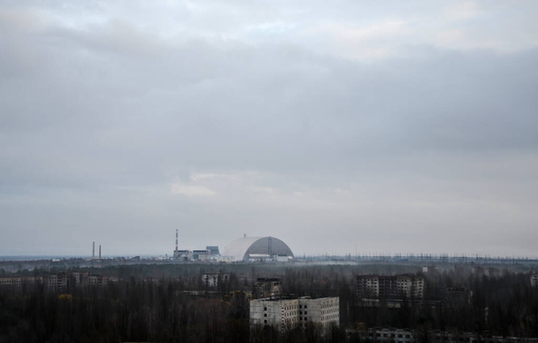 Вид на Саркофаг (новий притулок) реактора 4 атомна електростанція і Прип'ять привидів міста на Чорнобильській зоні відчуження, Україна  - Фото, зображення