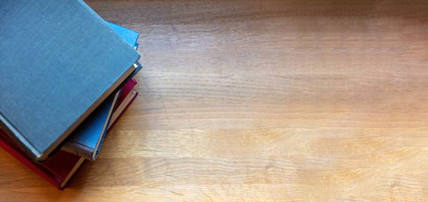 Libro de tapa en blanco apilado en una mesa. Cuadernos antiguos cerrados en el fondo de escritorio de madera de la biblioteca, vista superior. Copia spac - Foto, Imagen