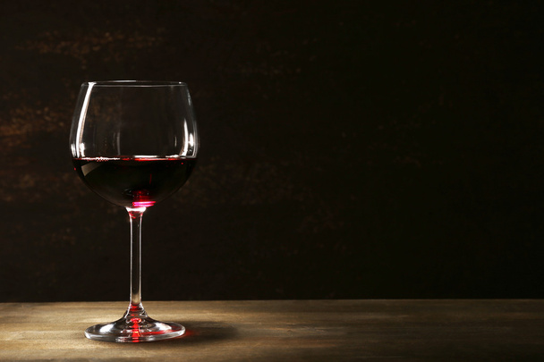 Goblet of red wine on wooden table on wooden wall background - Valokuva, kuva