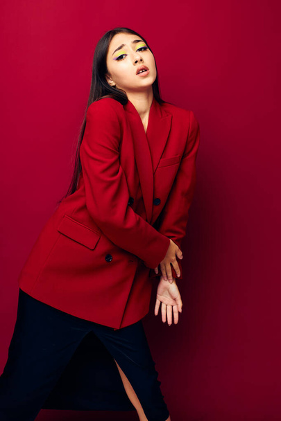 молода жінка мода позує в червоній куртці червоний фон незмінний
 - Фото, зображення