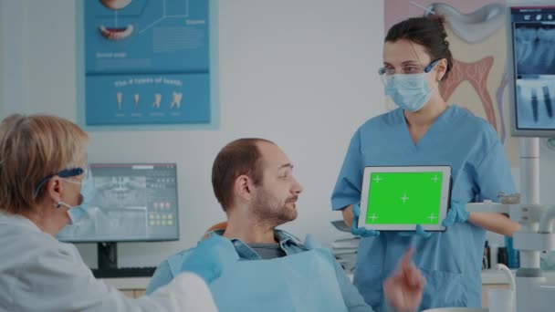 Paciente e equipe de odontologia olhando para tablet com tela verde - Filmagem, Vídeo