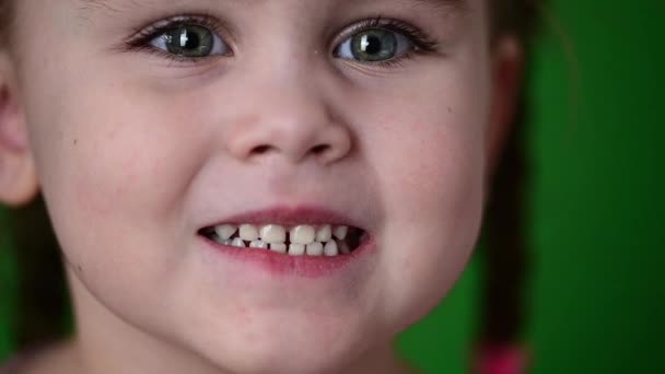 A menina mostra os dentes de leite, os dentes brancos do bebê, a higiene oral, o movimento lento da criança. - Filmagem, Vídeo