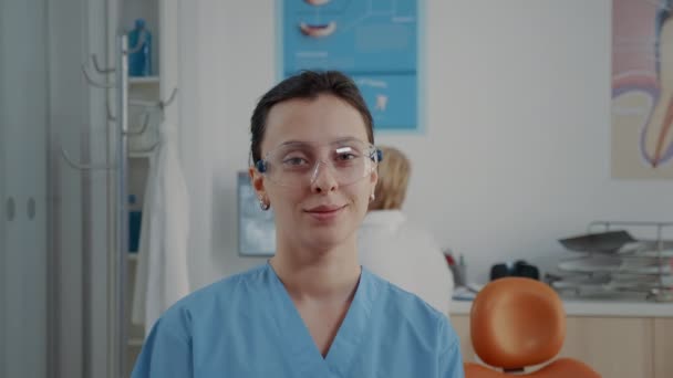 Retrato de enfermera de ortodoncia mirando la cámara en la oficina de odontología - Metraje, vídeo