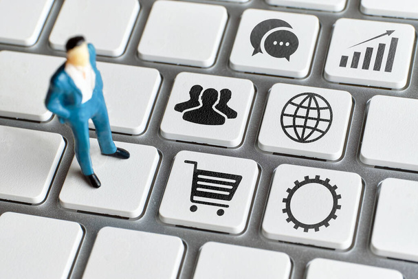 Konsept CRM veya Müşteri İlişkileri Yönetimi. Soyut bir yönetici simgelerle birlikte bir klavyenin üzerinde durur - Fotoğraf, Görsel
