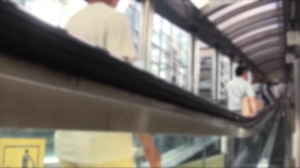 Visión desenfocada borrosa de personas asiáticas que usan escaleras mecánicas desde el distrito de Soho. Gran caja de escalera mecánica de metal. Escaleras mecánicas en movimiento mientras los viajeros suben - Metraje, vídeo