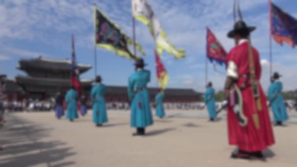Blurred defocused view of row armed guards in ancient traditional soldier uniforms on old royal residence Gyeongbokgung Palace of Seoul - Кадры, видео