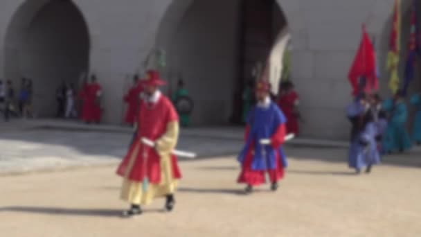 Plan déconcentré de gardes armés rangés en uniformes de soldat traditionnels anciens sur l'ancienne résidence royale Palais Gyeongbokgung de Séoul, arrière-plan flou dans la scène - Séquence, vidéo