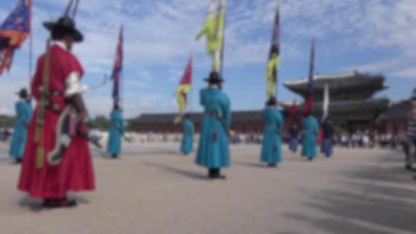 Defocused shot of row armed guards in ancient traditional soldier uniforms on old royal residence Gyeongbokgung Palace of Seoul, blurred background in the scene - Footage, Video