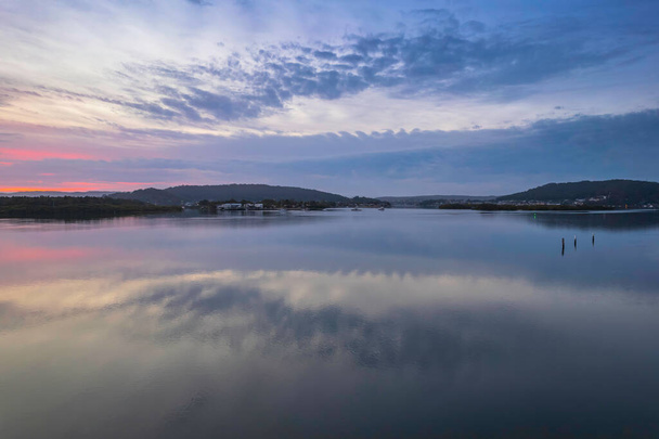 Sunrise, clouds and reflections at Woy Woy Waterfront on the Central Coast, NSW, Australia. - Foto, afbeelding