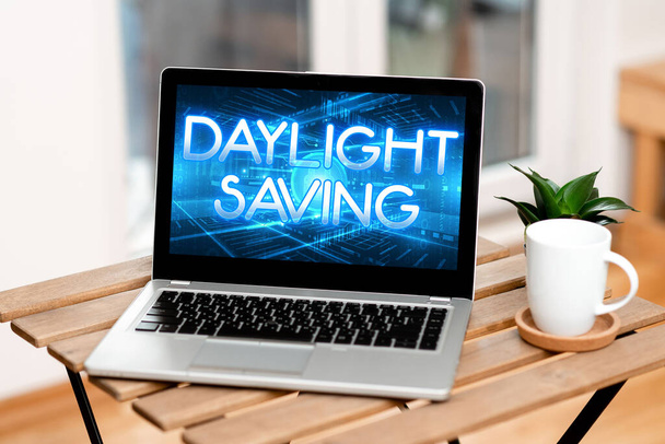 Text showing inspiration Daylight Saving. Internet Concept Storage technologies that can be used to protect data Laptop Resting On A Table Beside Coffee Mug And Plant Showing Work Process. - Photo, Image