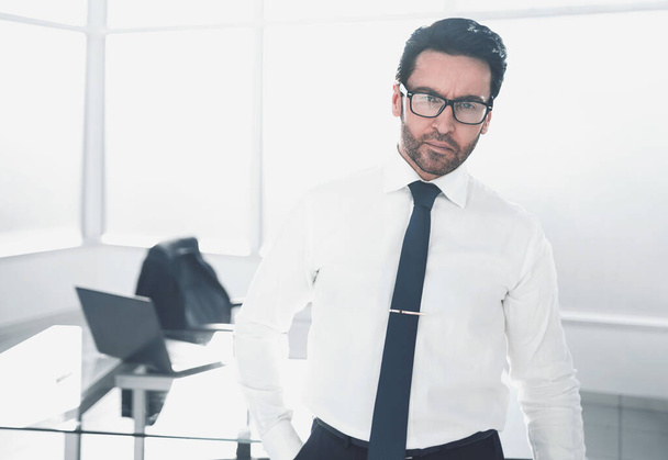 confident businessman standing in a spacious office - Zdjęcie, obraz