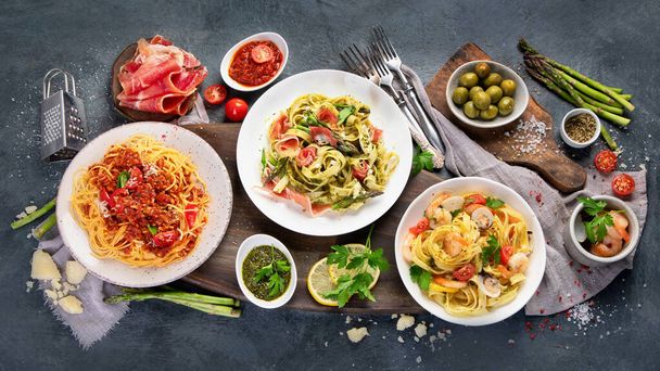 Pasta assortment on dark background. Traditional Italian Food concept. Top view, flat lay, copy space - Fotó, kép
