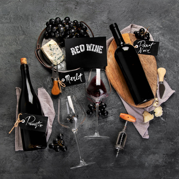 Red wine assortment with appetizers on gray background. Traditional alcohol drinks. Top view, flat lay - Foto, Imagen