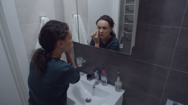 Černá žena čištění obličeje s kosmetickou bavlněnou podložkou, odstranění make-upu - Záběry, video