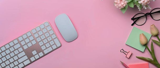 Bovenaanzicht draadloos toetsenbord, plakkerige notities en glazen op roze achtergrond. - Foto, afbeelding
