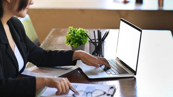 Обрезанный снимок деловая женщина с помощью ноутбука компьютер и проверки отчетов. - Фото, изображение