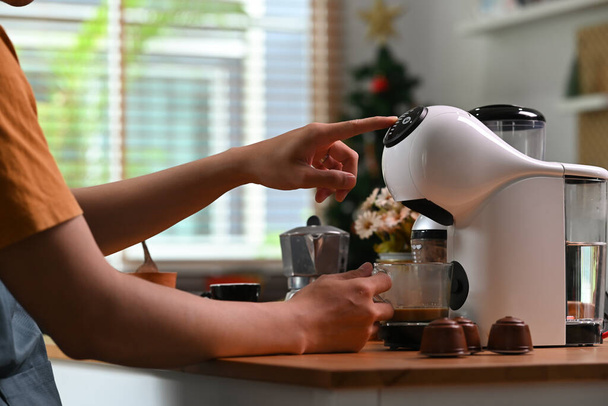 Cropped shot young man making coffee with a coffee machine in the kitchen. - 写真・画像