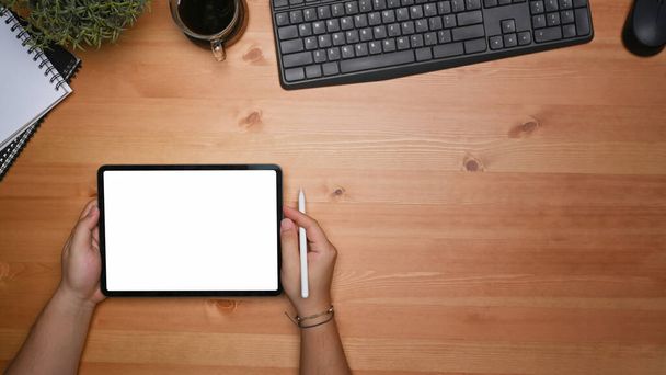 Manos de hombre sosteniendo maqueta de tableta digital con pantalla blanca. - Foto, Imagen