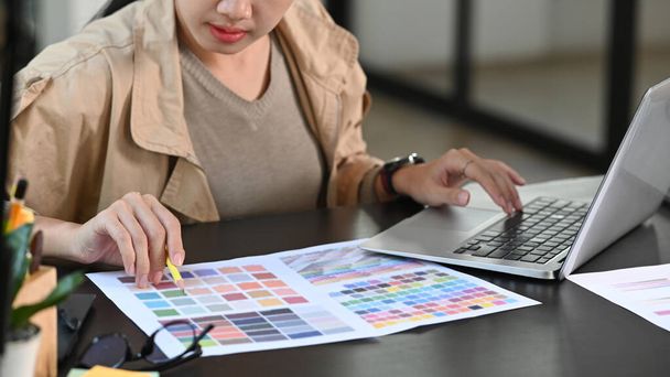 Przycięte strzał grafik kobieta pracuje z paletą kolorów w biurze biurko. - Zdjęcie, obraz