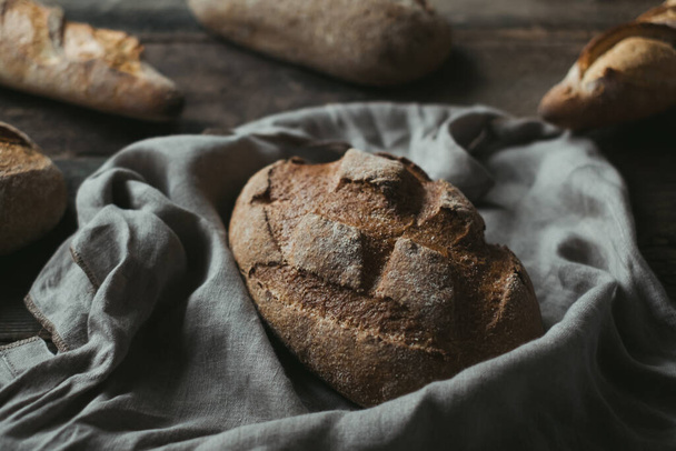 Freshly baked bread rustic wooden table background,. High quality photo - Φωτογραφία, εικόνα