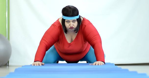 Fat young woman doing sports exercise on floor to lose belly fat, overweight - Fotó, kép
