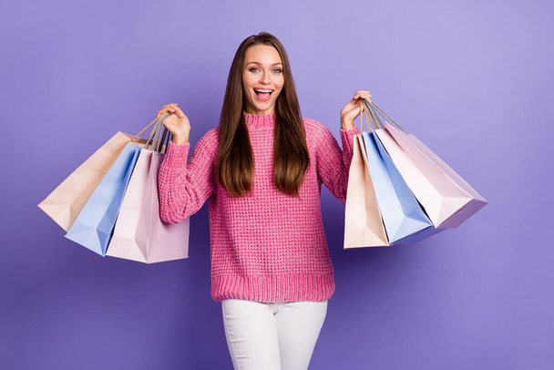 Photo of young happy excited smiling beautiful girl hold shopping bags shopaholic isolated on purple color background. - Foto, imagen