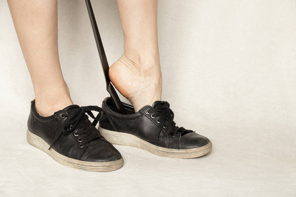 dívčí boty černé tenisky s klaksonem na bílém pozadí, boty, černé dámské tenisky - Fotografie, Obrázek