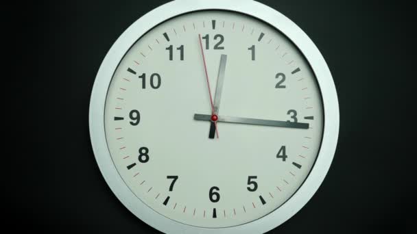 White wall clock shows the slowly of time. The movement of the hands of the clock passed slowly. On the black background. - Video