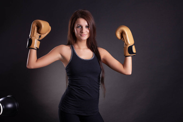 Young pretty boxer woman on black background - 写真・画像