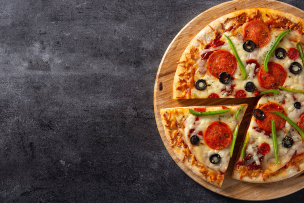 Pizza suprema tradicional sobre piedra negra. Copiar espacio - Foto, imagen