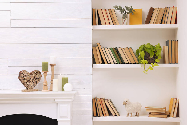 Collection of books and decor elements on shelves indoors - Foto, Imagen