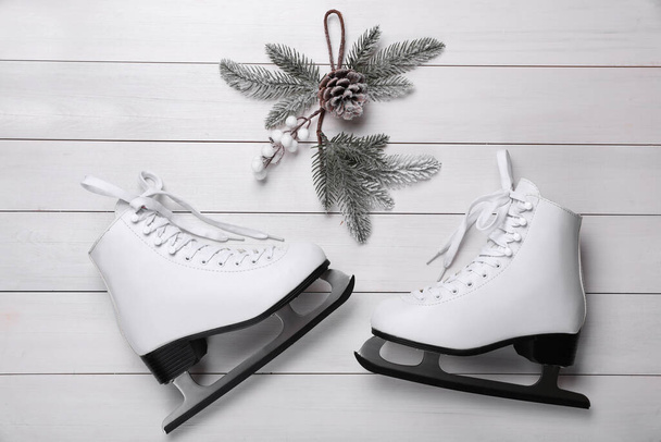 Pair of ice skates and Christmas decor on white wooden background, flat lay - Φωτογραφία, εικόνα