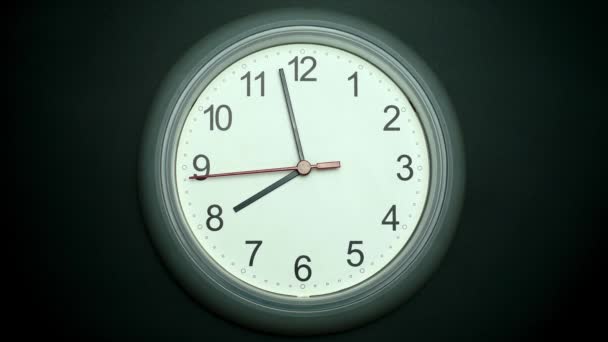 White wall clock tells the time in five minutes until eight o'clock. Time passed slowly. On the black background. - Кадры, видео