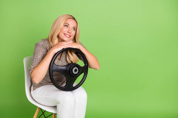 Photo of thoughtful dreamy woman wear brown shirt sitting holding steering wheel looking empty space isolated green color background. - Fotografie, Obrázek
