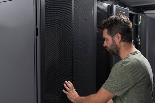 A couple of server engineers cooperate in high tech data centers. Technicians team updating hardware inspecting system performance in super computer server room or cryptocurrency mining farm. - Photo, image