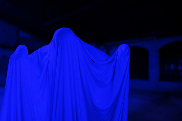 L'uomo è in abiti bianchi e mostra un volto spaventoso guardando un vecchio edificio raccapricciante, sembrare fantasma di notte per il concetto di Halloween Festival, Copia spazio - Foto, immagini