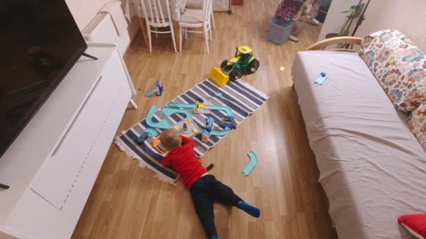 Chłopiec z tabletem leżącym na podłodze - Materiał filmowy, wideo
